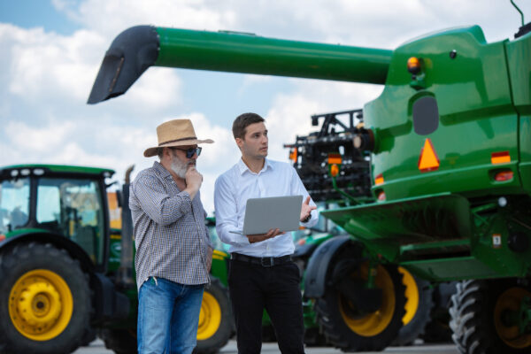 A farmer with a tractor, combine at a field in sunlight. Confident, bright colors RPL vs short courses- Noble training